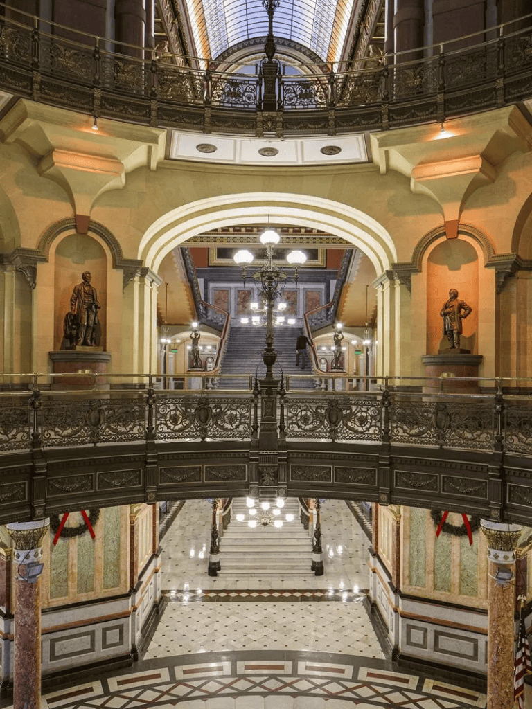 Elegant historic interior of a grand shopping arcade with ornate ironwork and classical statues.
