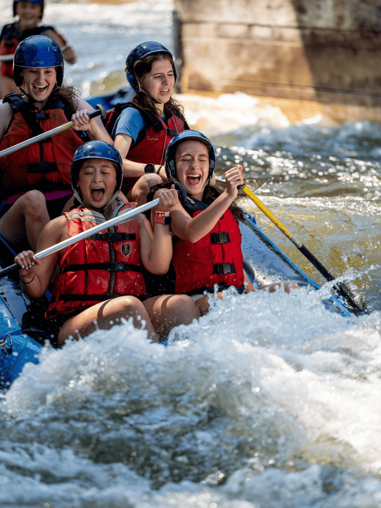 Exciting white-water rafting adventure with happy young group in safety gear.