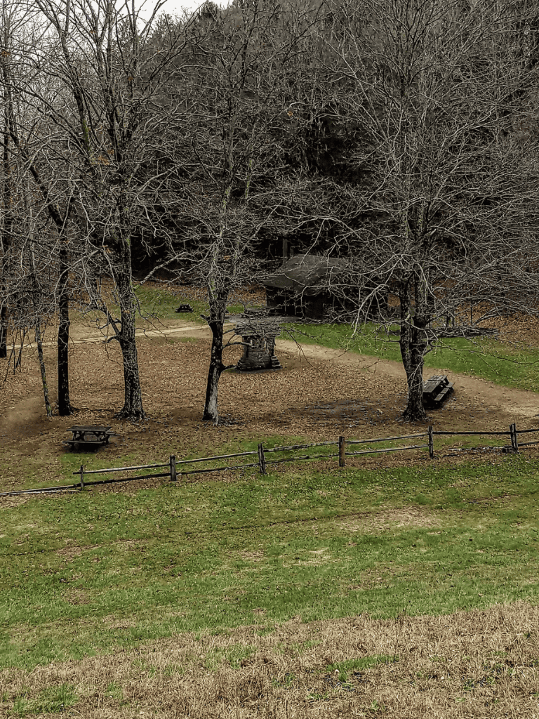 Tranquil park with bare trees, picnic tables, and rustic shelter, perfect for outdoor gatherings and relaxation.