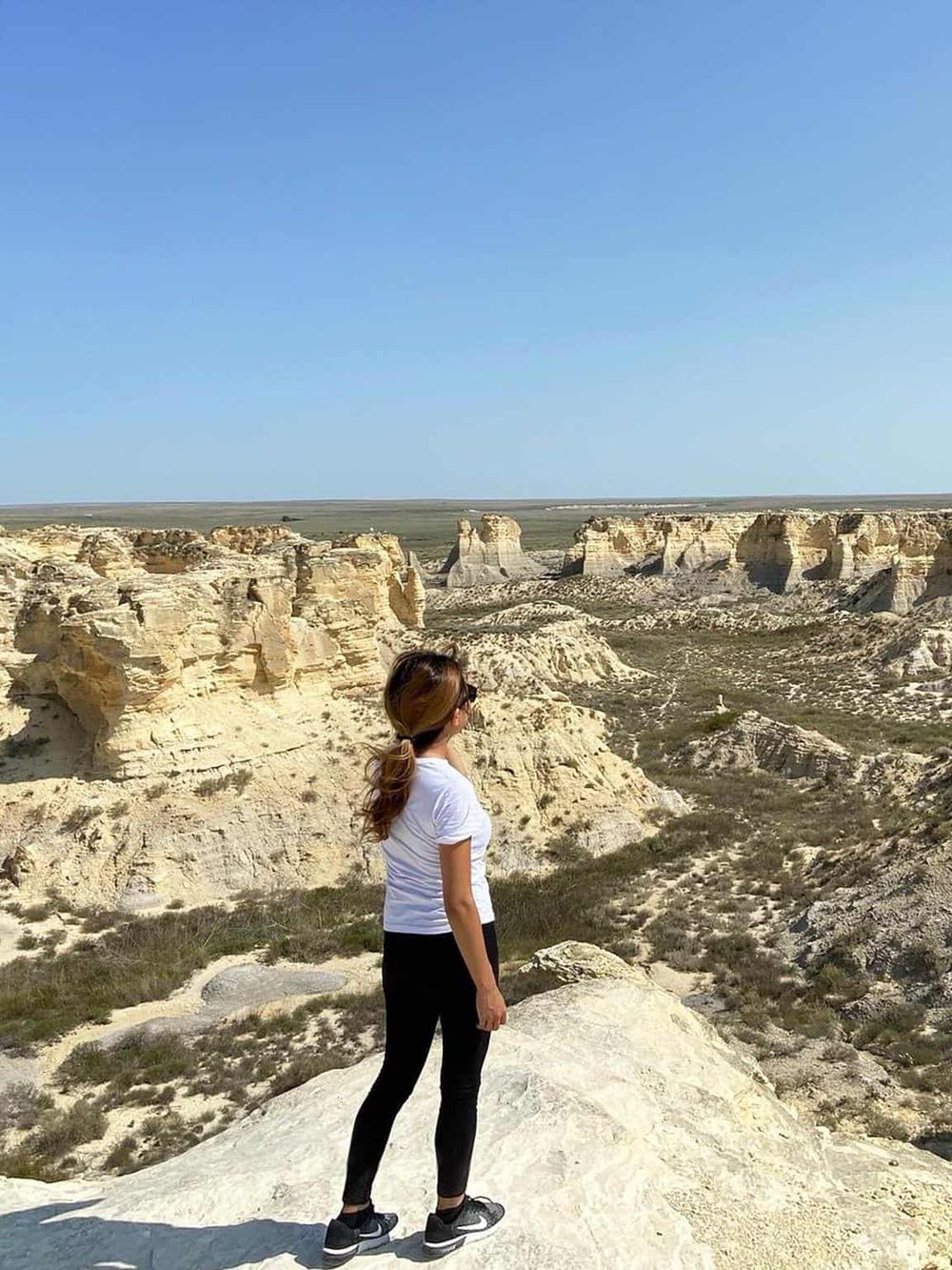 Breathtaking view of white limestone formations with a woman exploring the stunning landscape. Perfect for travel and adventure enthusiasts.