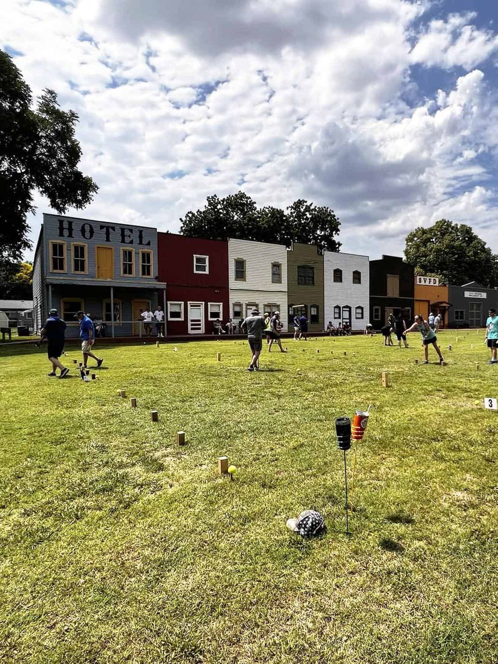 Colorful hotel buildings during an outdoor golf event under a partly cloudy sky.