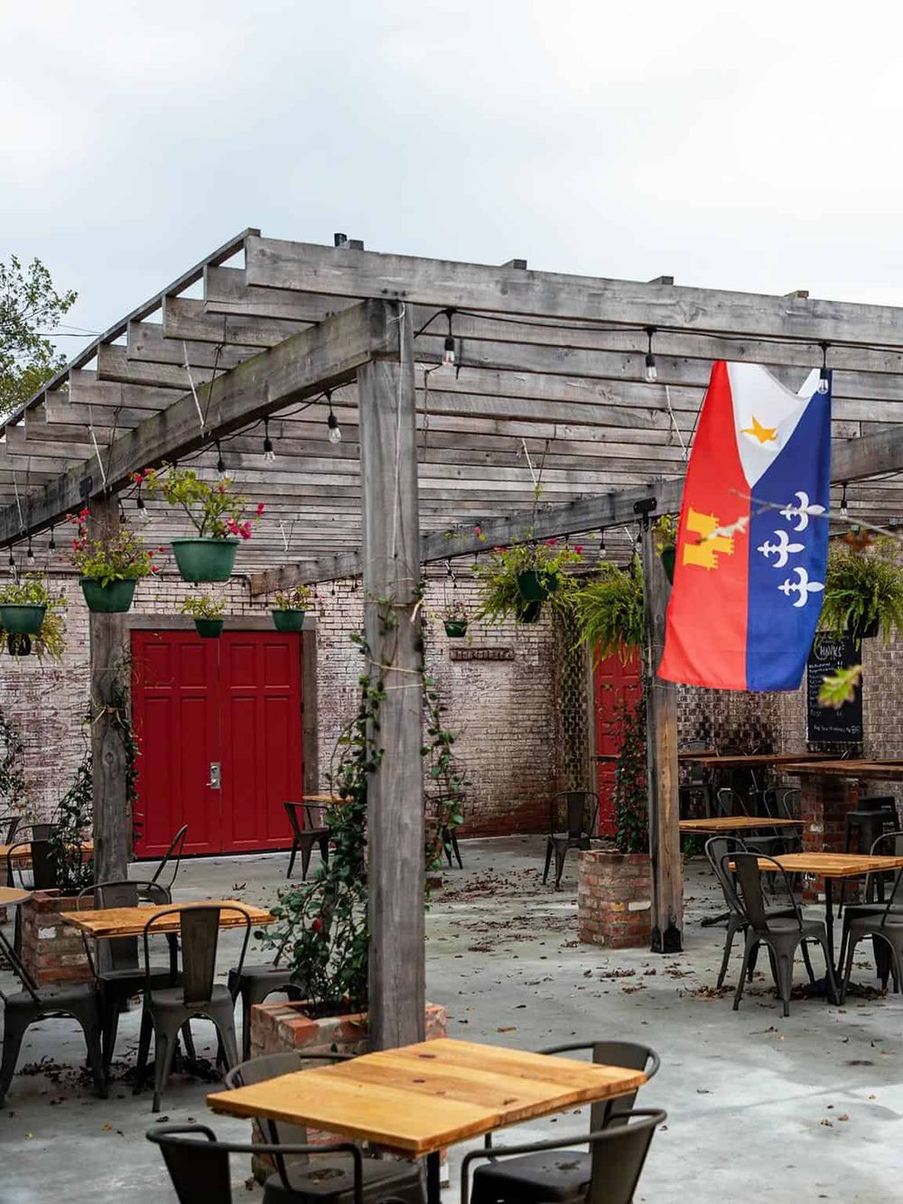 Outdoor dining area with string lights, hanging flower pots, and a flag, perfect for exploring QuestForDirections.
