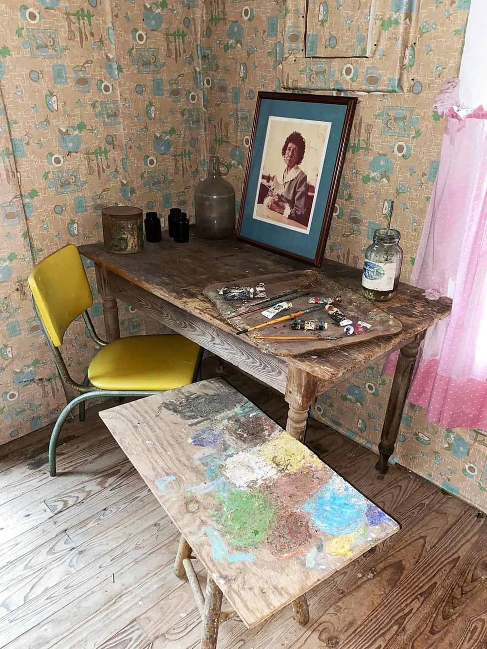 Vintage art studio with paint supplies and a framed portrait, showcasing creative workspace design and artistic inspiration.