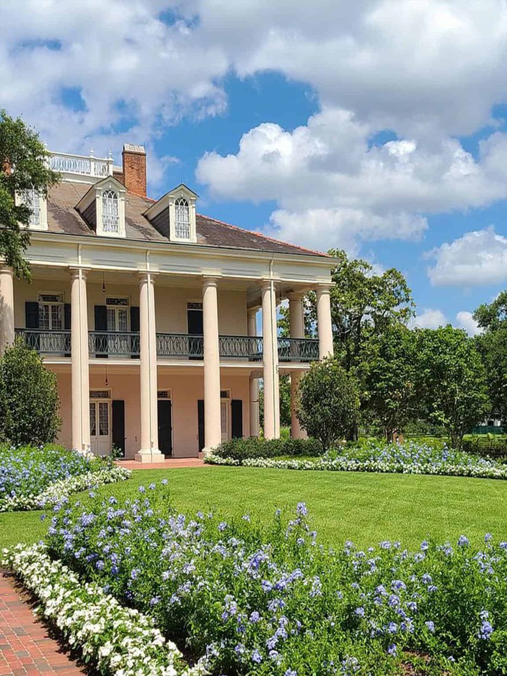 Elegant historic mansion with lush garden, ideal for touristic exploration and scenic photography.