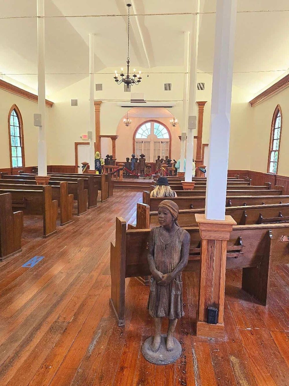 Vintage church interior with wooden pews and statue of girl for religious guidance.