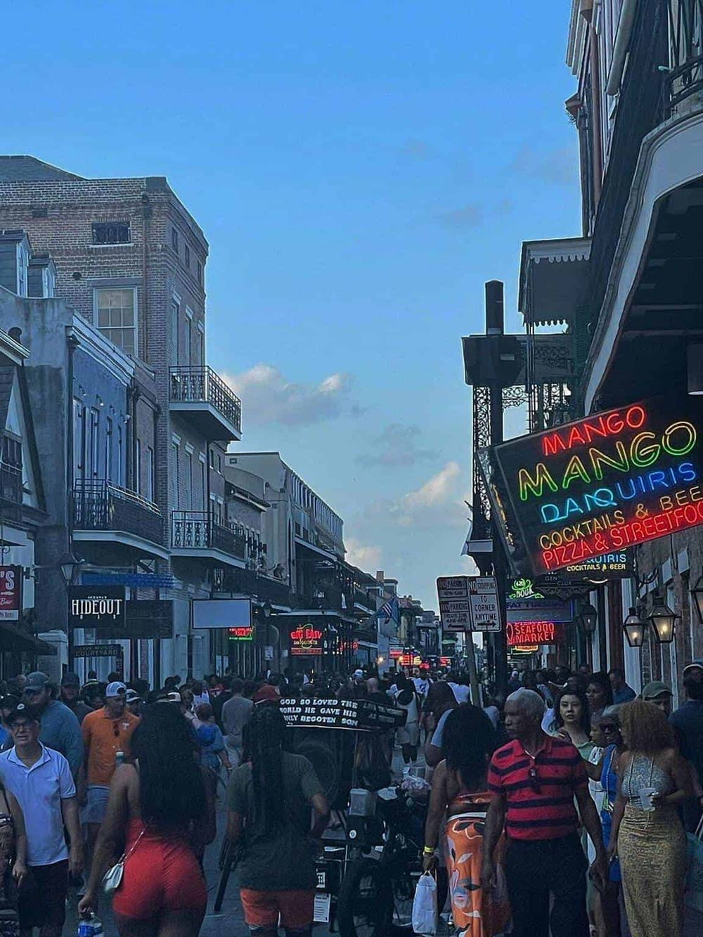 Bustling street scene in Nashville with neon signs, diverse crowd, and historic architecture.