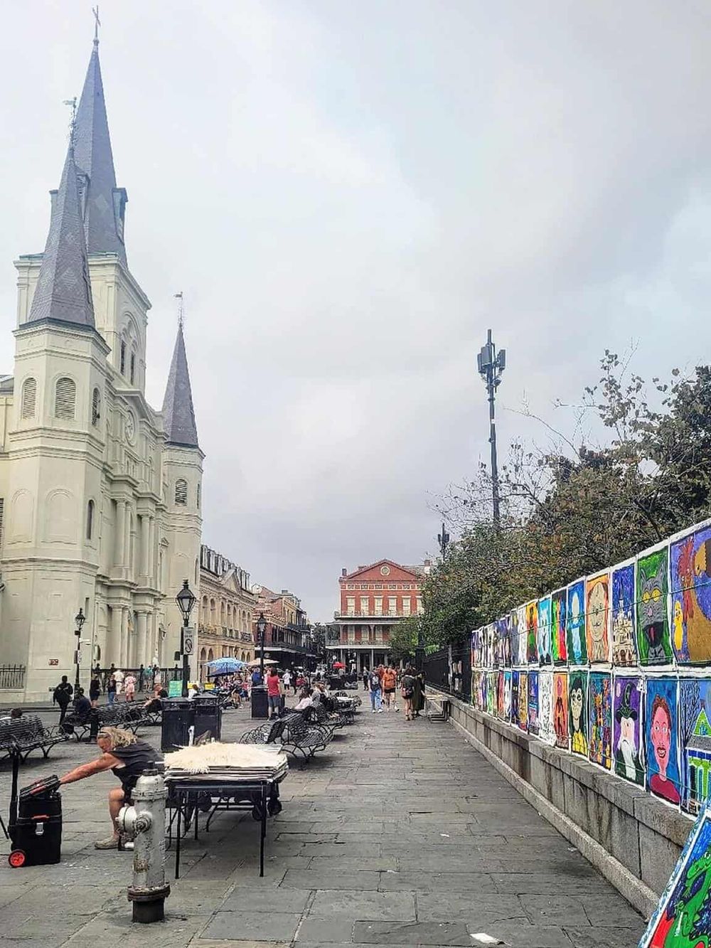 Colorful street art murals in a lively urban plaza, featuring historic architecture and vibrant community atmosphere.