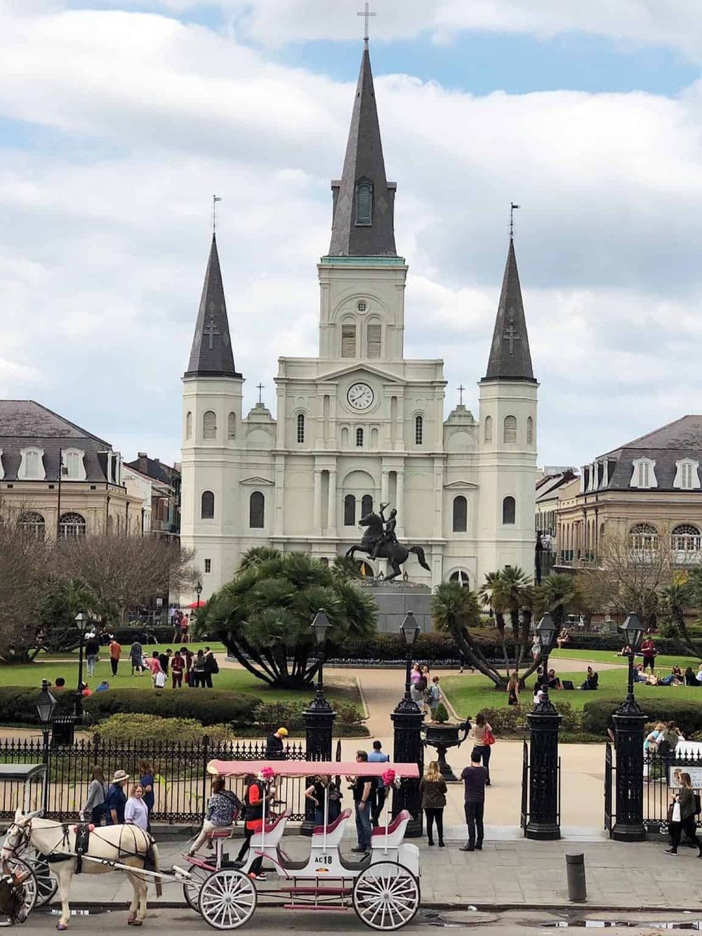 Colorful church with a clock tower and surrounding park, popular tourist destination.