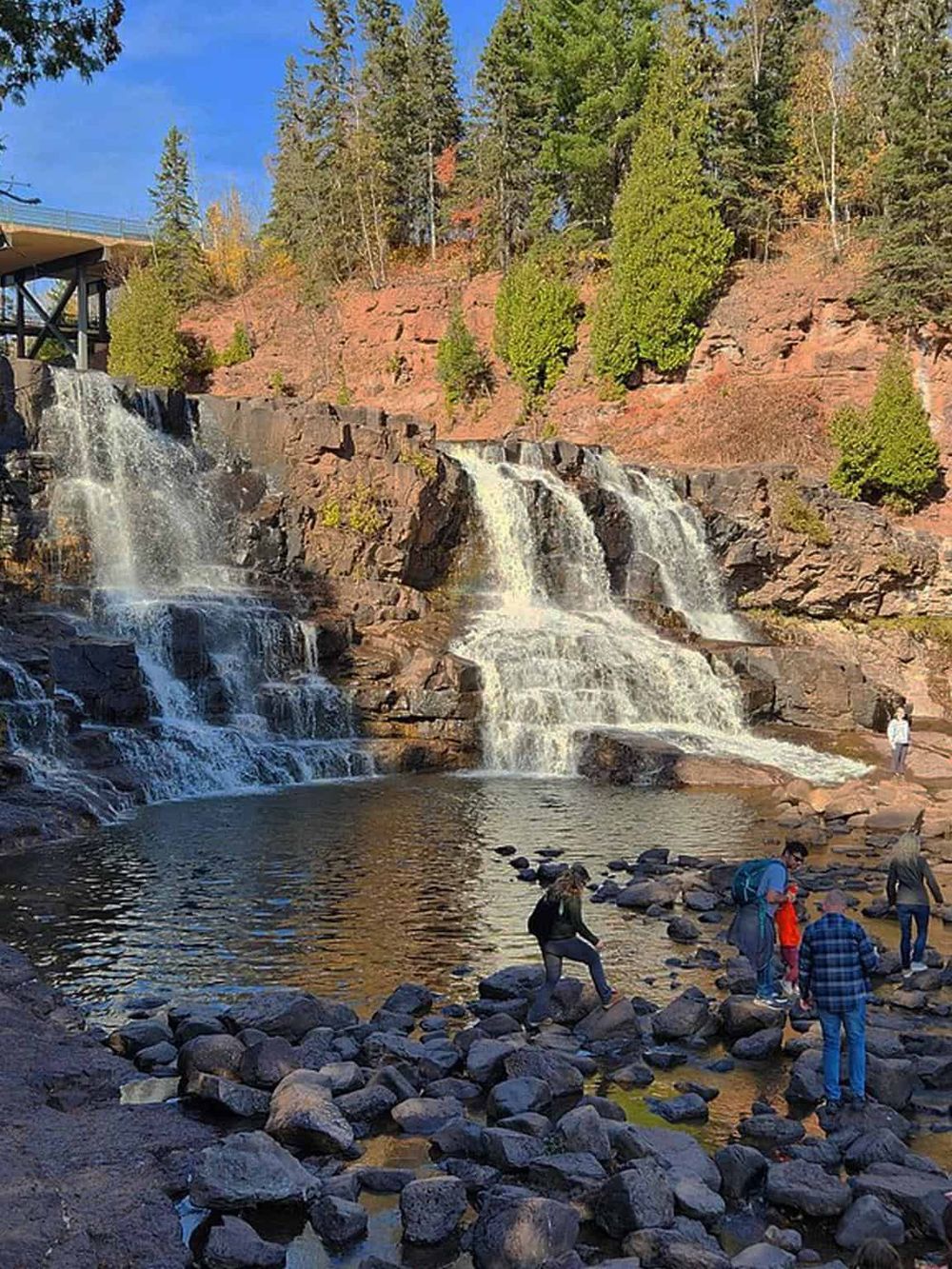 Grace Falls in Colorado with visitors exploring the scenic waterfall and rocky terrain.
