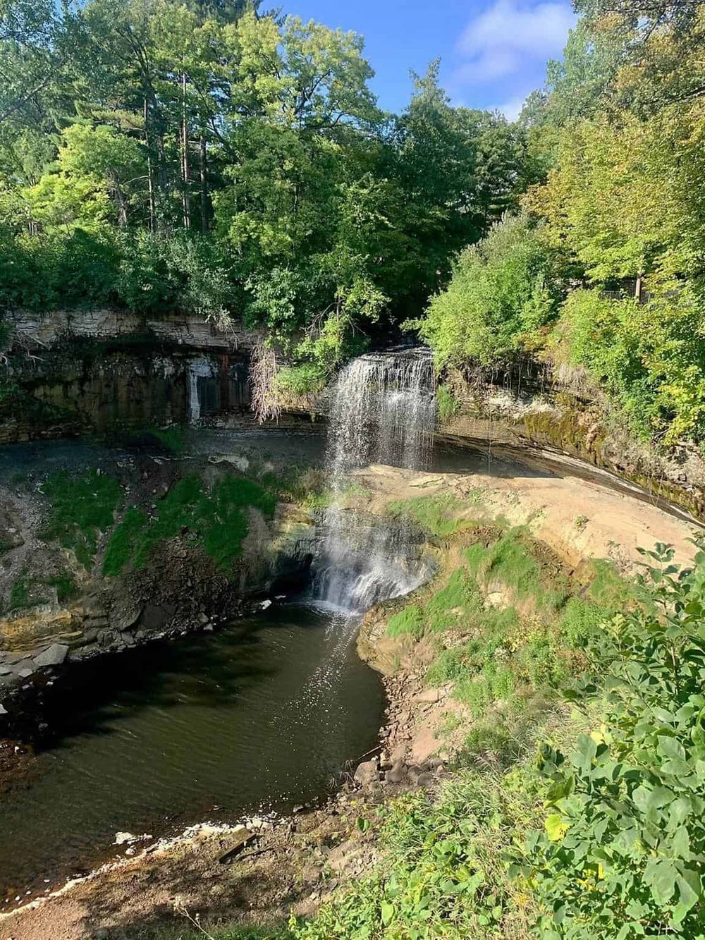 Tranquil waterfall in lush green forest, perfect for nature exploration and outdoor adventures.