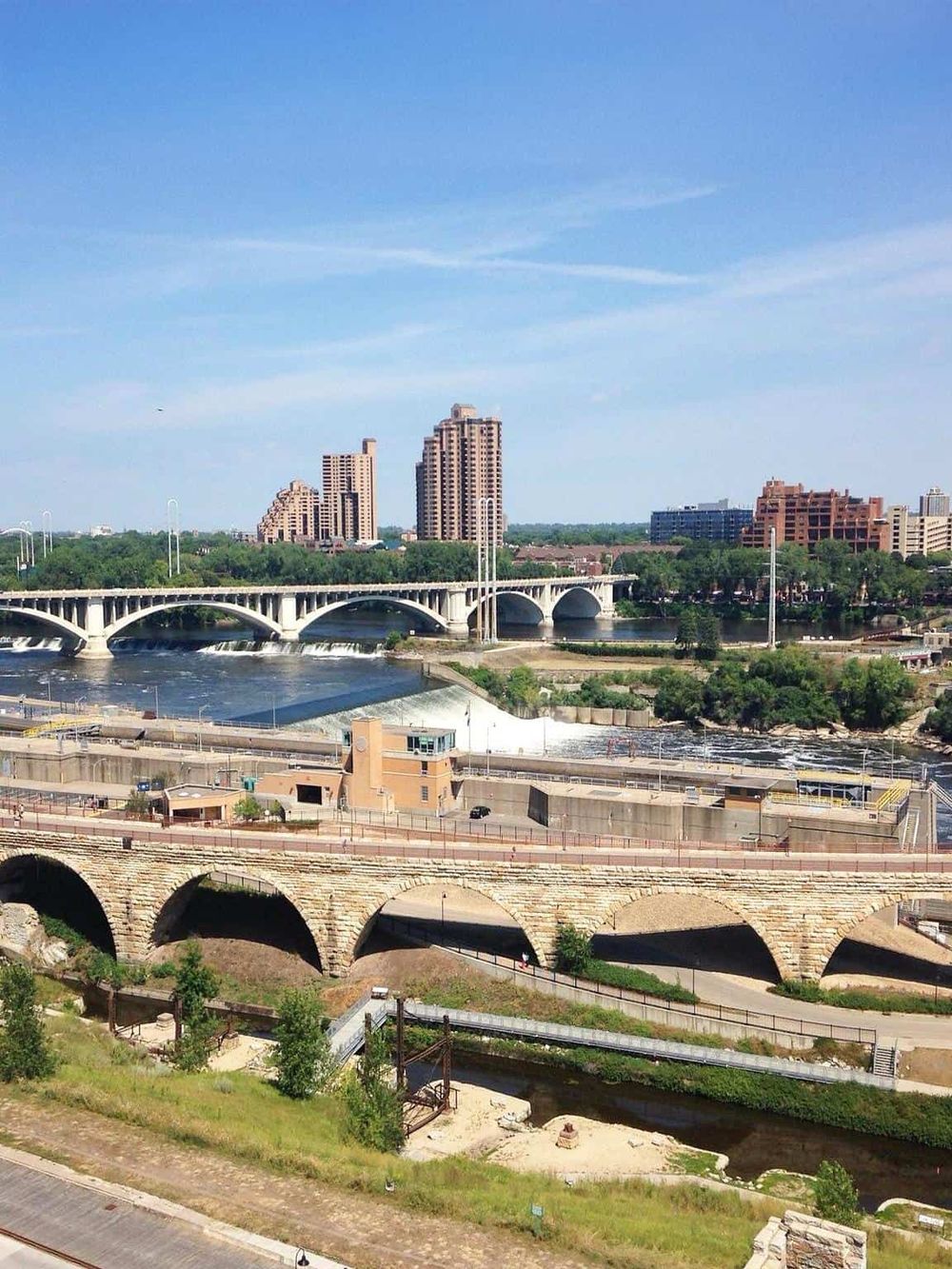 Scenic cityscape with bridges, river, and high-rise buildings in the background.