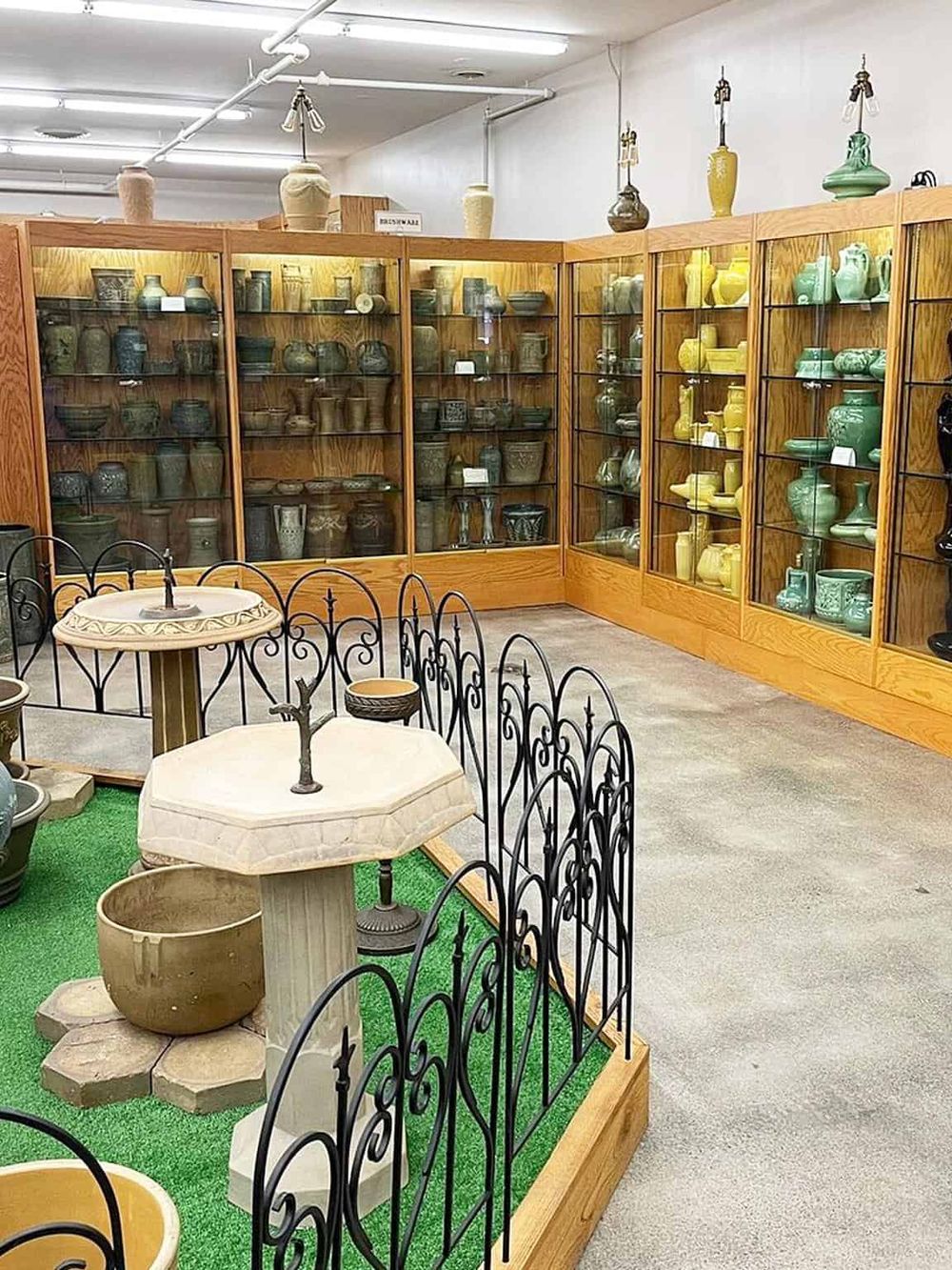 Colorful ceramic vases and pottery displayed in a wooden cabinet at QuestForDirections store.