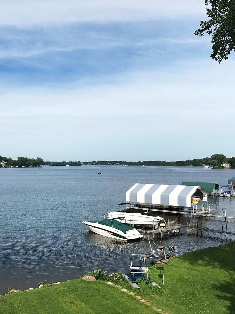 Serene lakeside marina with boats and docking area, perfect for boat rentals and watersports.