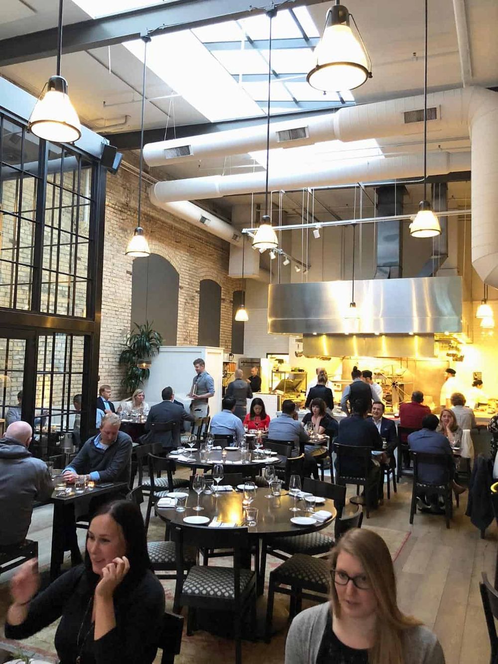 Modern restaurant interior with exposed brick walls and industrial lighting, offering a casual dining experience.