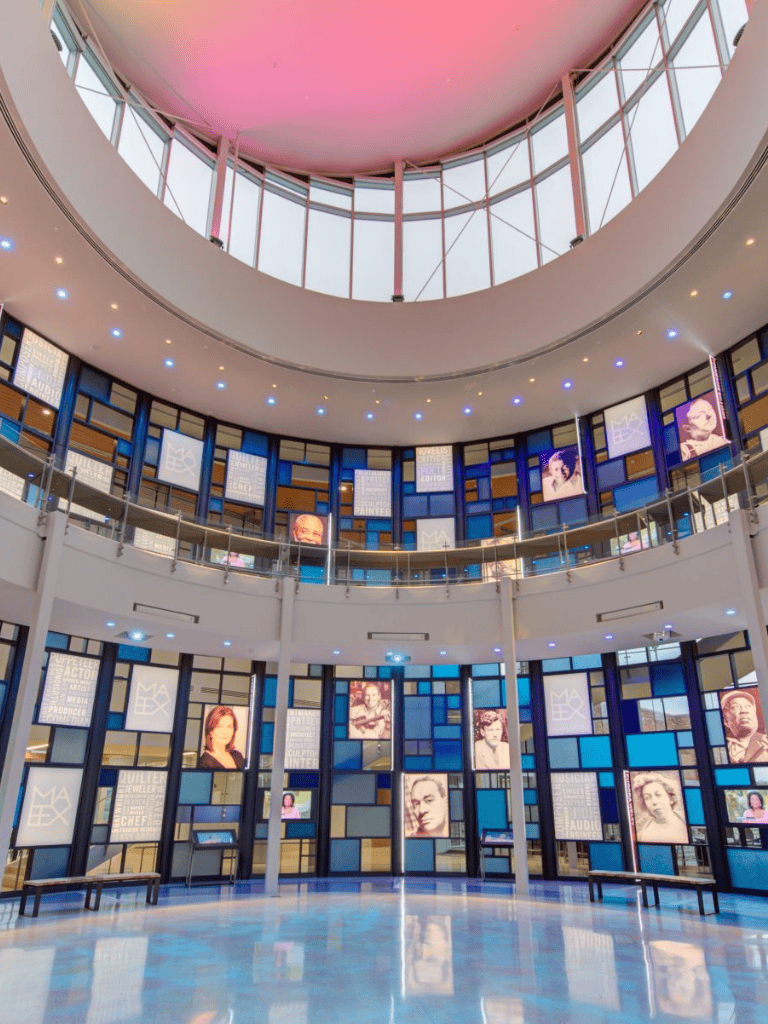 Bright modern interior with digital displays and artwork, showcasing QuestForDirections advertising at a creative venue.