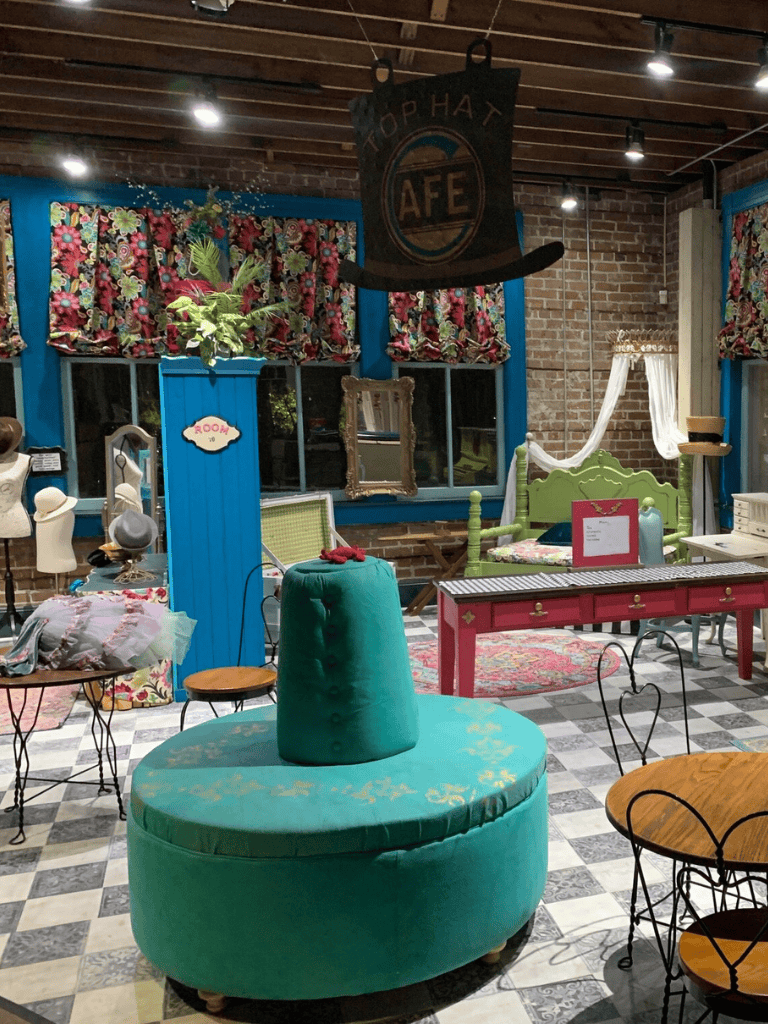 Colorful eclectic vintage boutique shop with bright furniture and floral curtains.