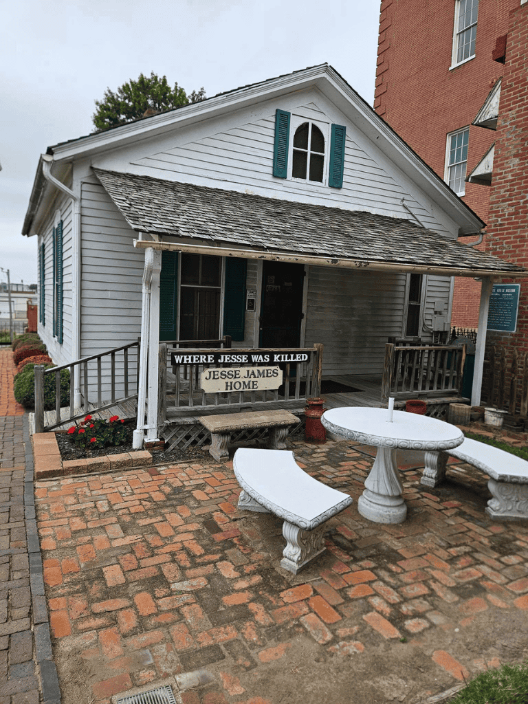 Jesse James Home Museum, historic site with white wooden house, outdoor patio, and memorial plaque in Missouri.