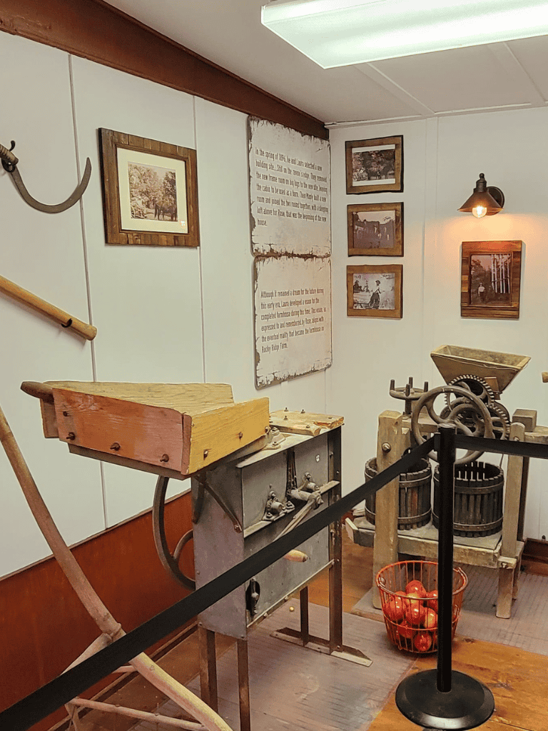 Antique apple cider press exhibit in Quest for Directions museum, showcasing vintage farming tools.