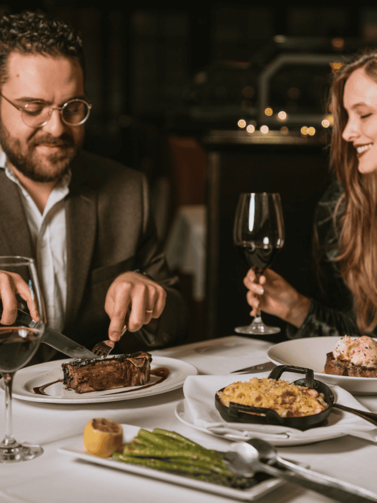 Fine dining at a romantic restaurant with steak, wine, and gourmet dishes.
