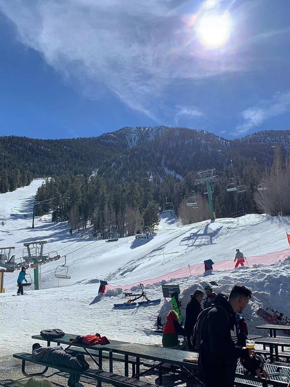 Snowy ski resort with chairlifts and skiers under sunny blue sky, Mountain adventure, winter sports, and outdoor recreation.