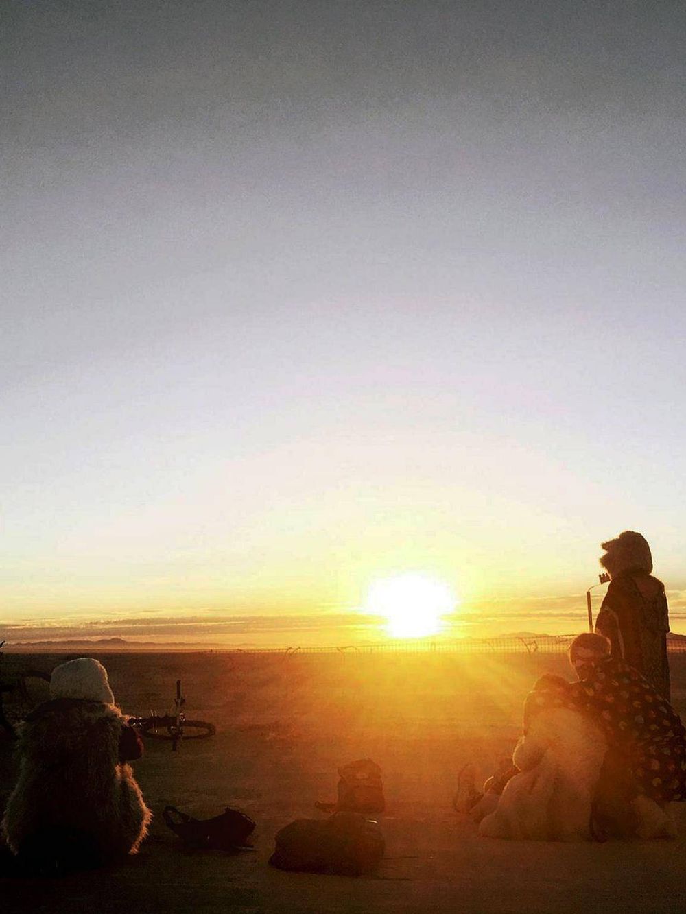 Sunset over desert with travelers and bicycles, inspiring adventure and exploration with QuestForDirections.