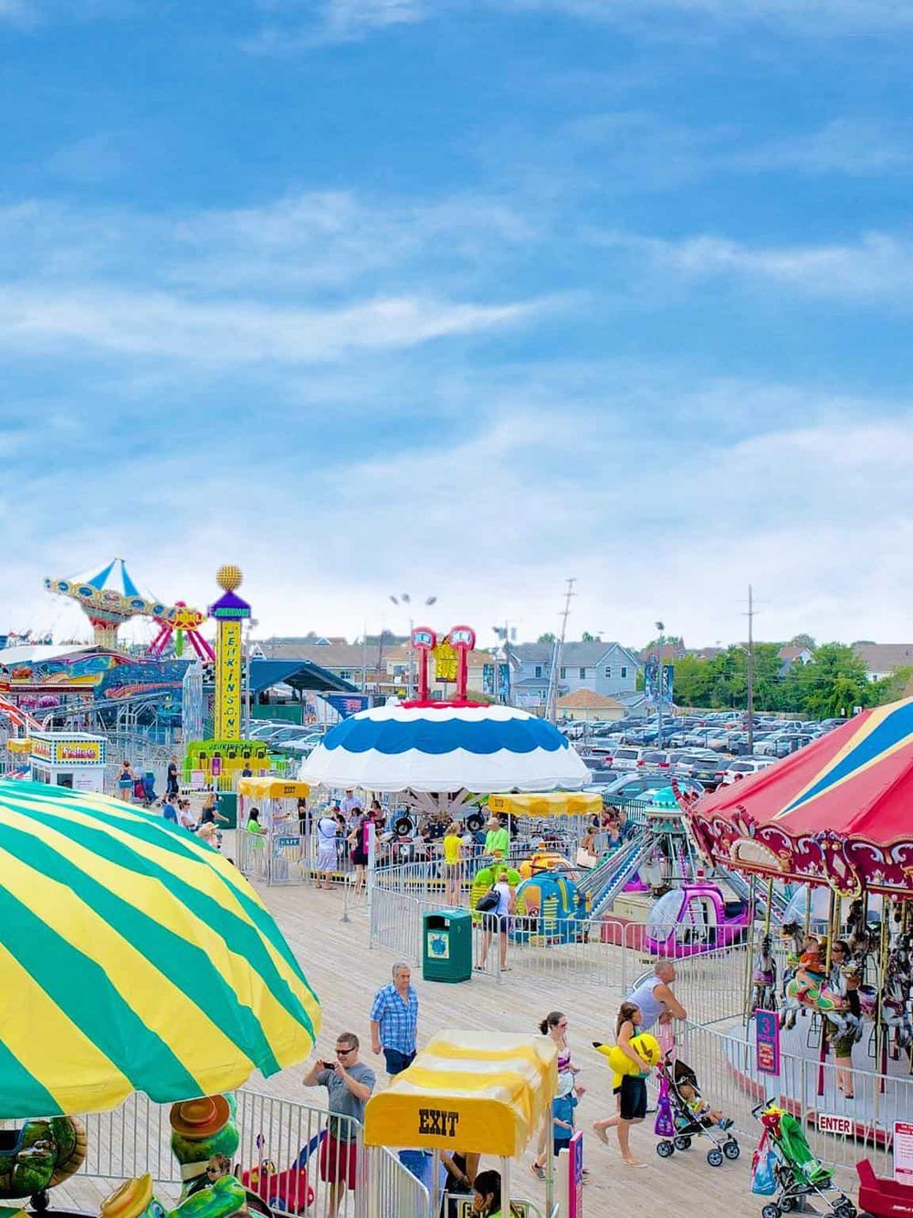 Colorful amusement park rides with families enjoying a day out, emphasizing entertainment and family activities.