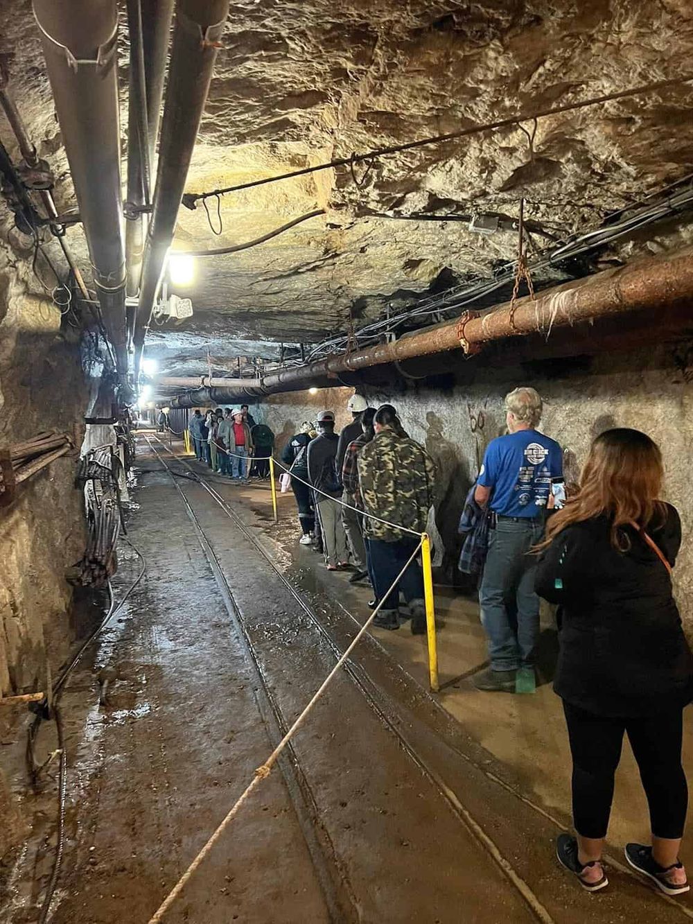 Underground tunnel tour at Quest for Directions, showcasing mining history and rugged terrain.