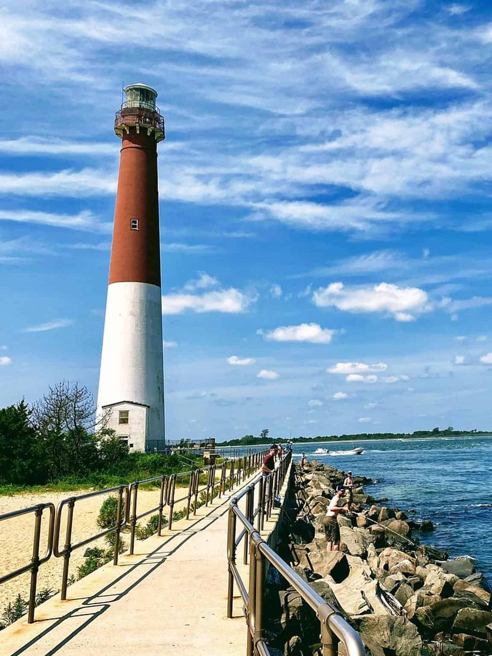 Lighthouse on the coast, scenic view, seaside escape, iconic lighthouse, water activities, oceanfront, travel destination, summer vacation spot, picturesque lighthouse, coastal landmark.