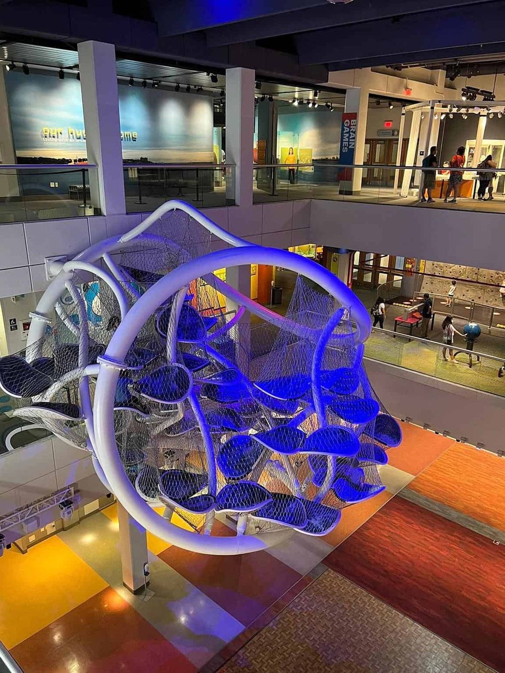 Vivid indoor play area with a modern, illuminated climbing structure and multiple levels for kids' entertainment.