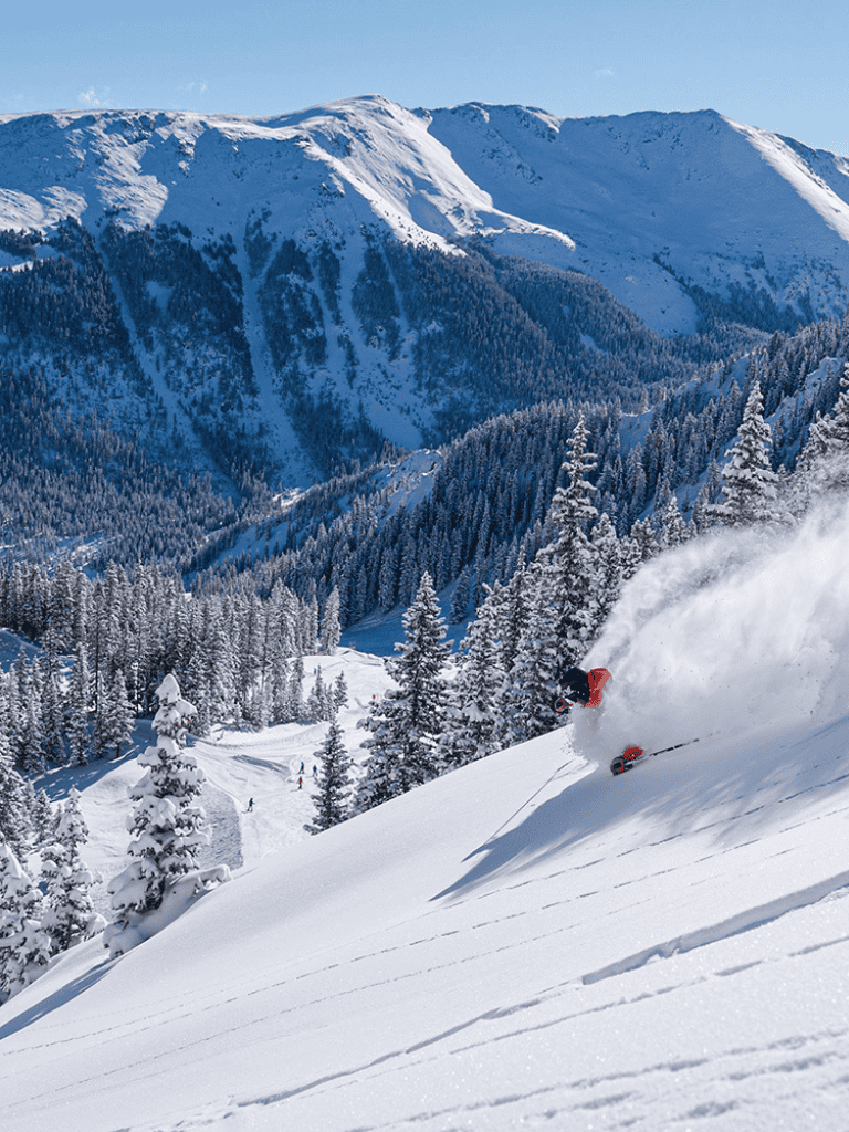 Powder snow and mountain ski slopes with skier on winter vacation in snowy landscape, QuestForDirections.