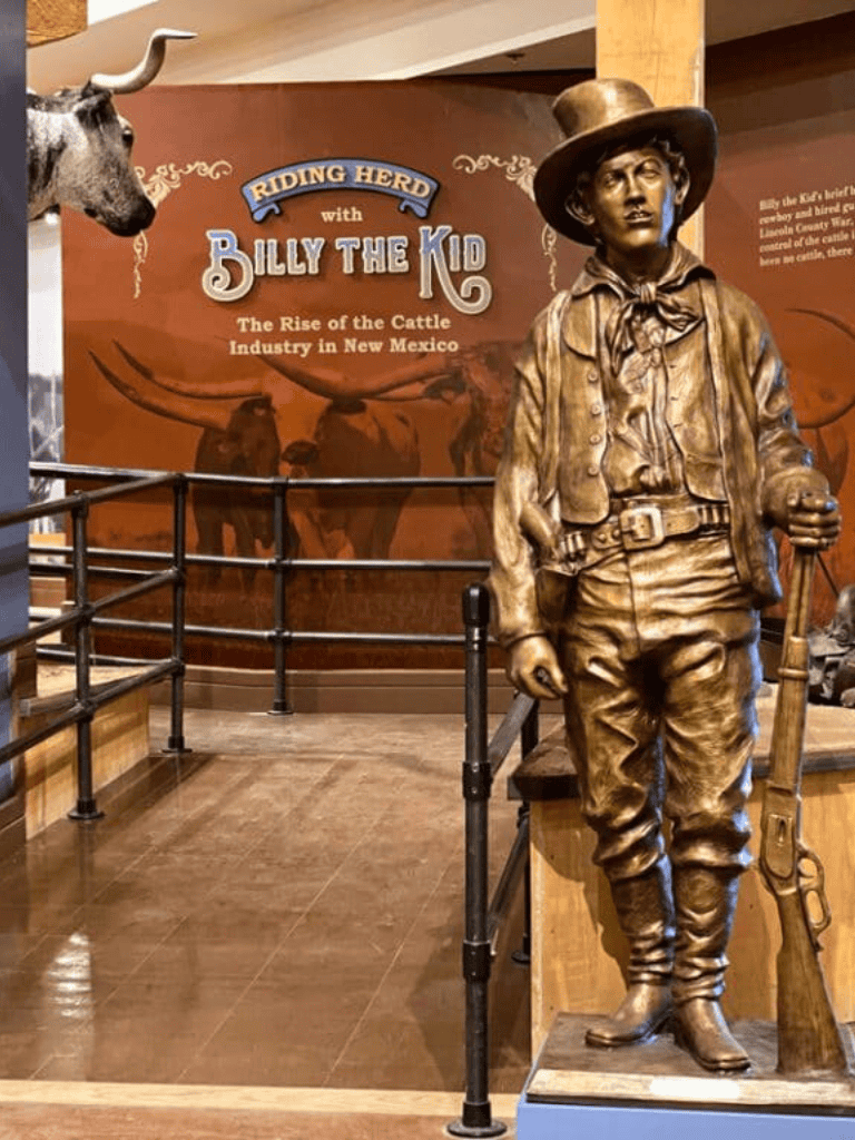 Bronze sculpture of Billy the Kid at QuestForDirections exhibit, celebrating New Mexico's cattle industry history.