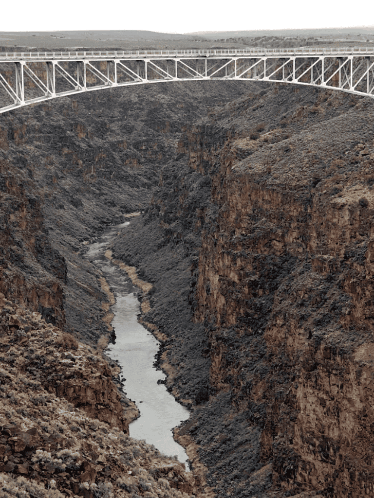 Clouds over the Grand Canyon with a bridge spanning the canyon walls, showcasing majestic natural beauty and scenic vistas.