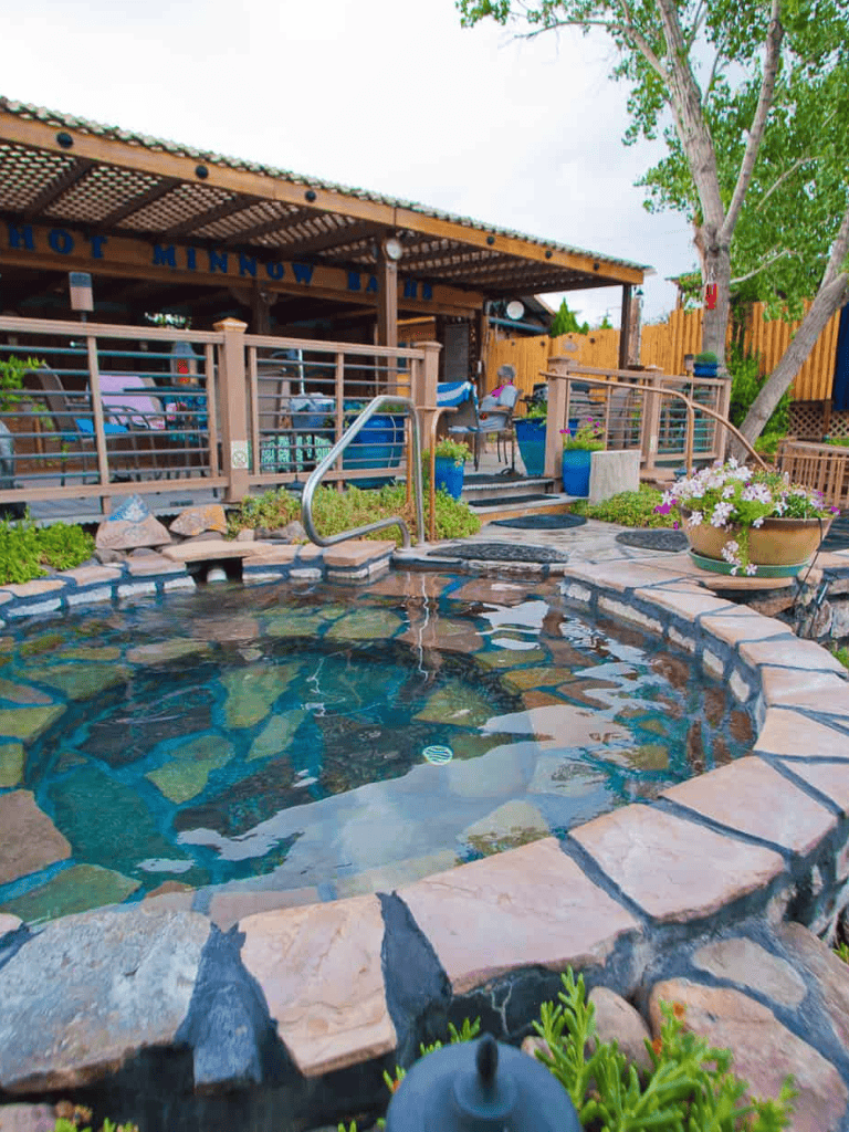 Relaxing hot tub with natural stone surround at Quest For Directions. Enjoy outdoor comfort and scenic views.