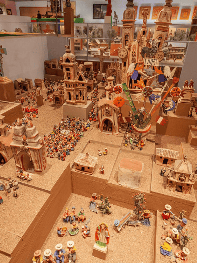 Colorful miniature Mexican village and carnival scene with detailed figurines and festive decorations.