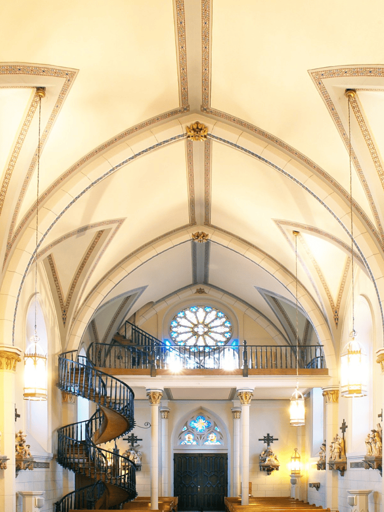 Graceful church interior with vaulted ceilings and stained glass windows, emphasizing spiritual architecture and design.