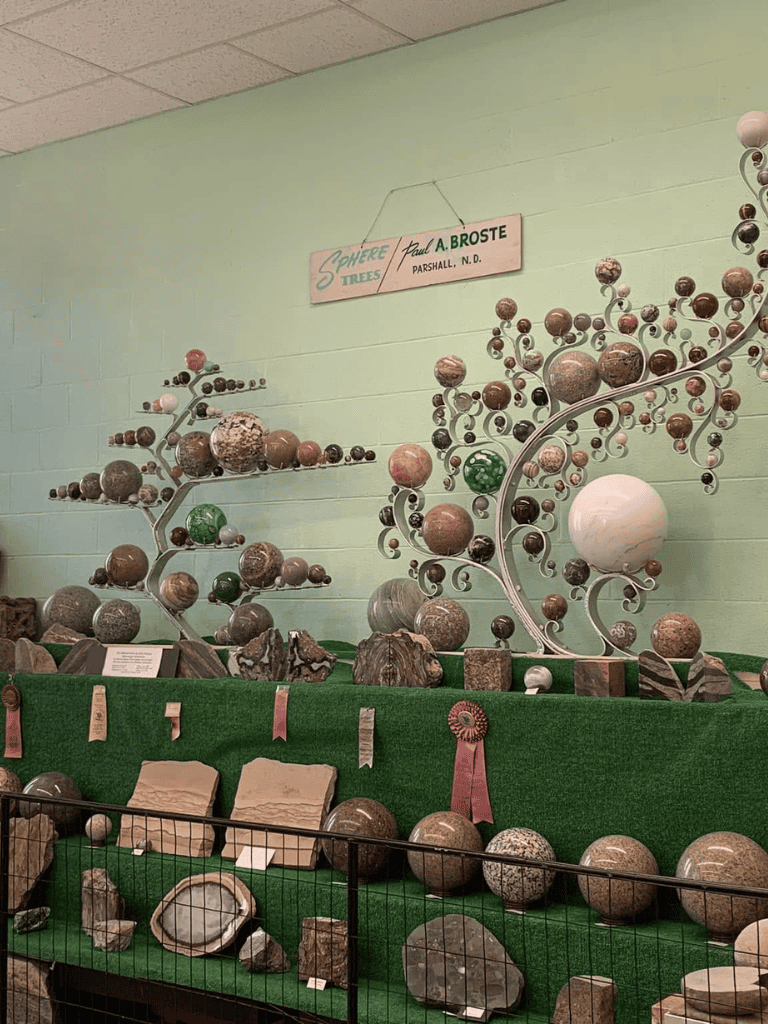 Natural stone sphere display at QuestForDirections outdoor decor exhibit, showcasing unique marble and granite garden art.