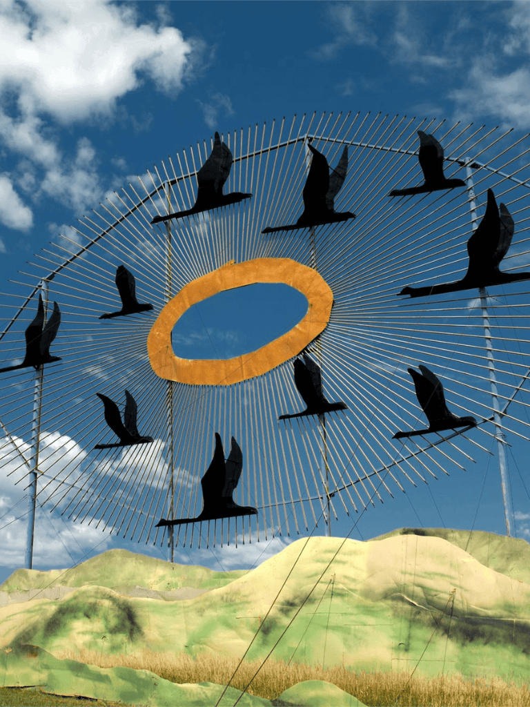 Bird-themed outdoor kite sculpture on a bright day with a blue sky.