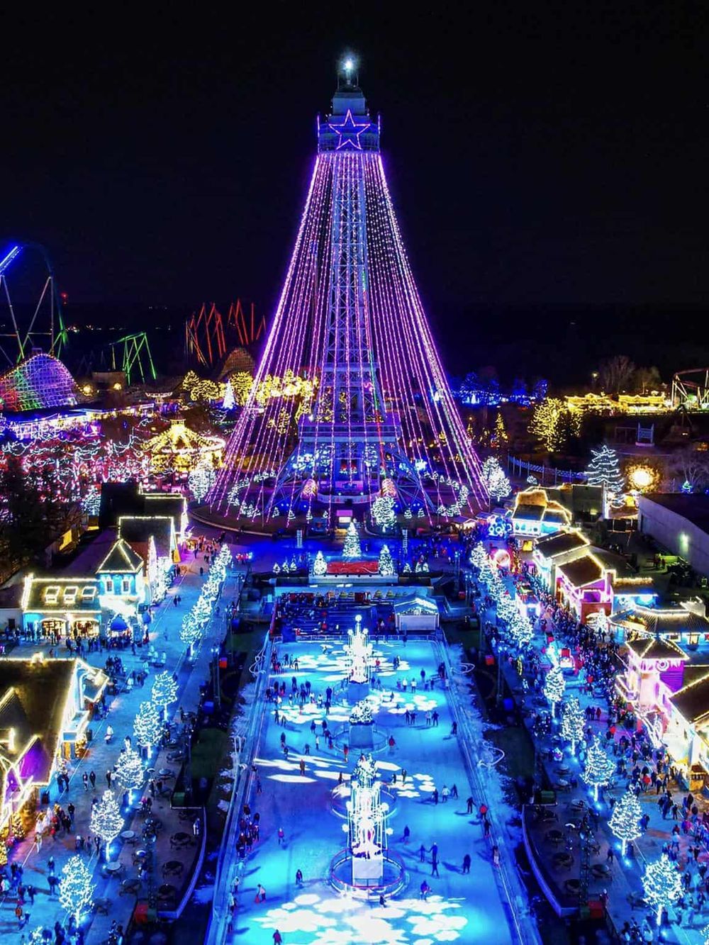Vibrant illuminated Ferris wheel and holiday ice skating rink at night, festive atmosphere at QuestForDirections event.