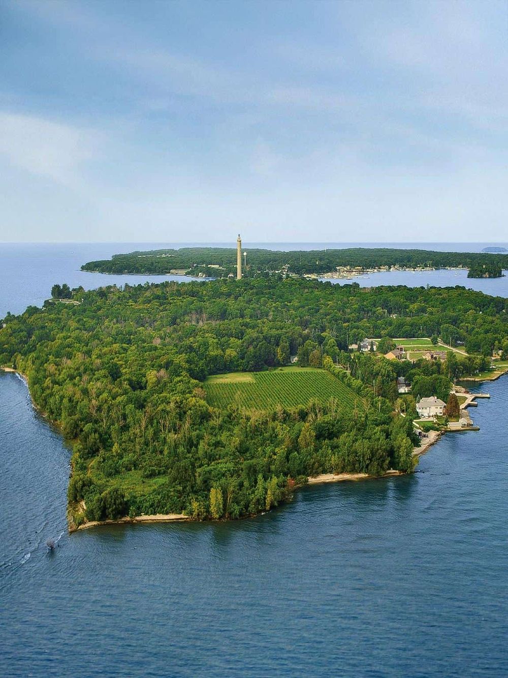 Aerial view of the scenic Lake Worth Island with lush greenery, scenic views, and a lighthouse in the distance.