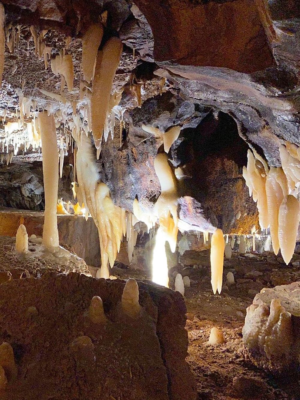Hidden caves with stalactites and stalagmites in a scenic underground passage.