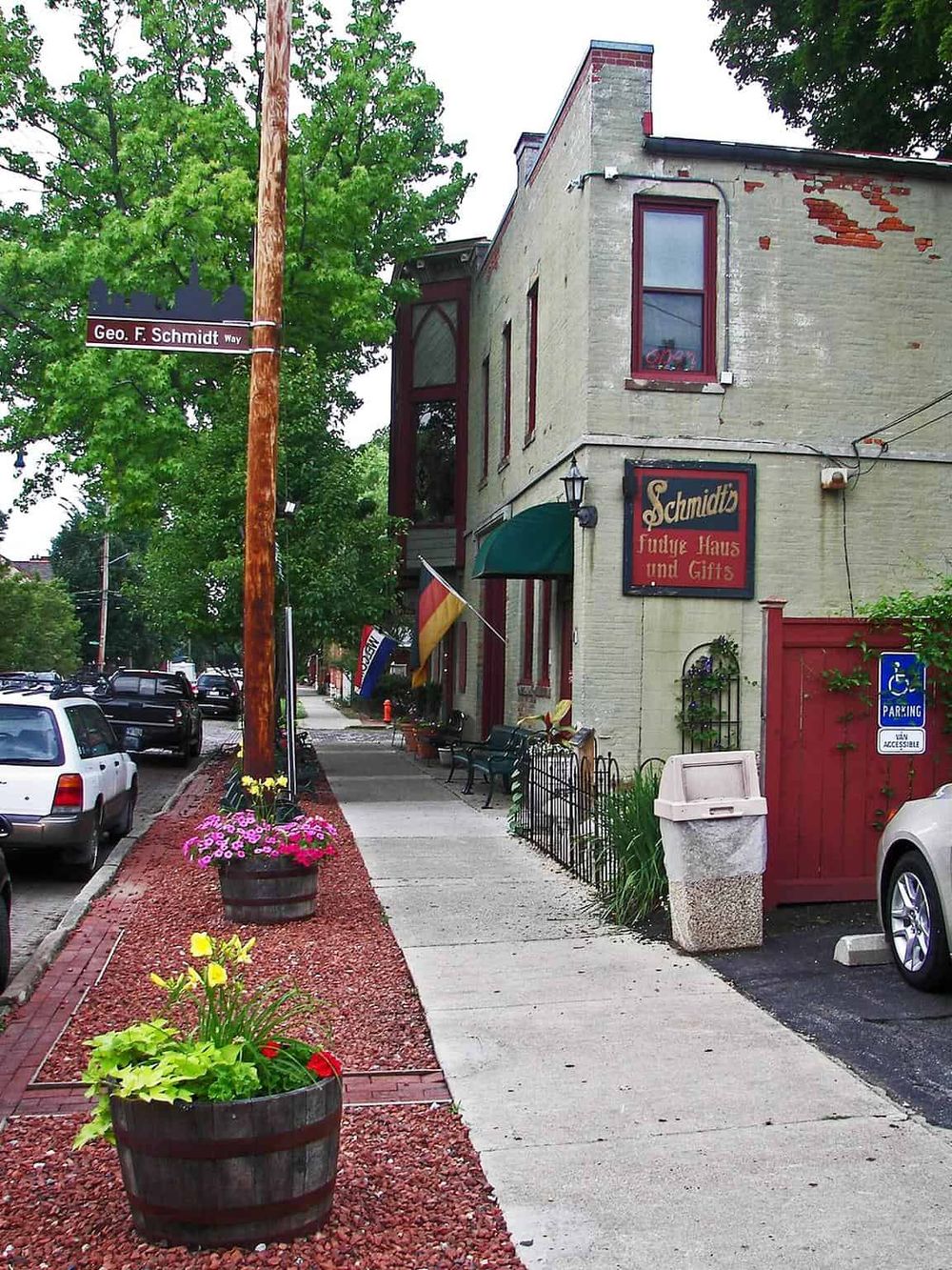 Charming historic building with colorful flower planters along sidewalk, cozy atmosphere, and signage for downtown boutique shop.