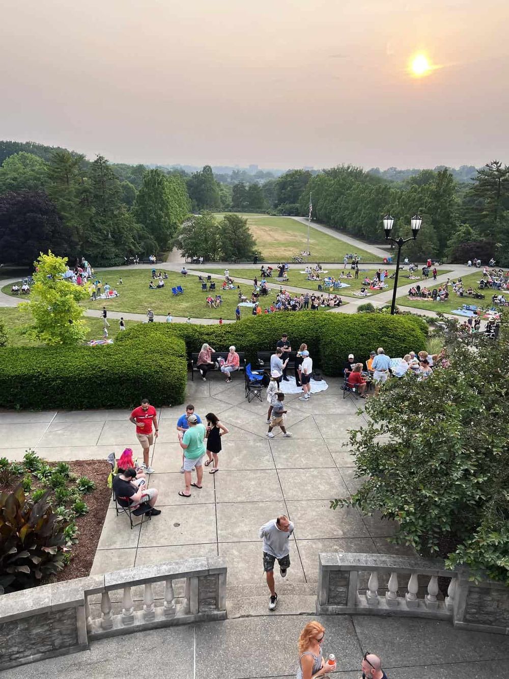 Vibrant park scene during sunset with families enjoying outdoor activities and gatherings.