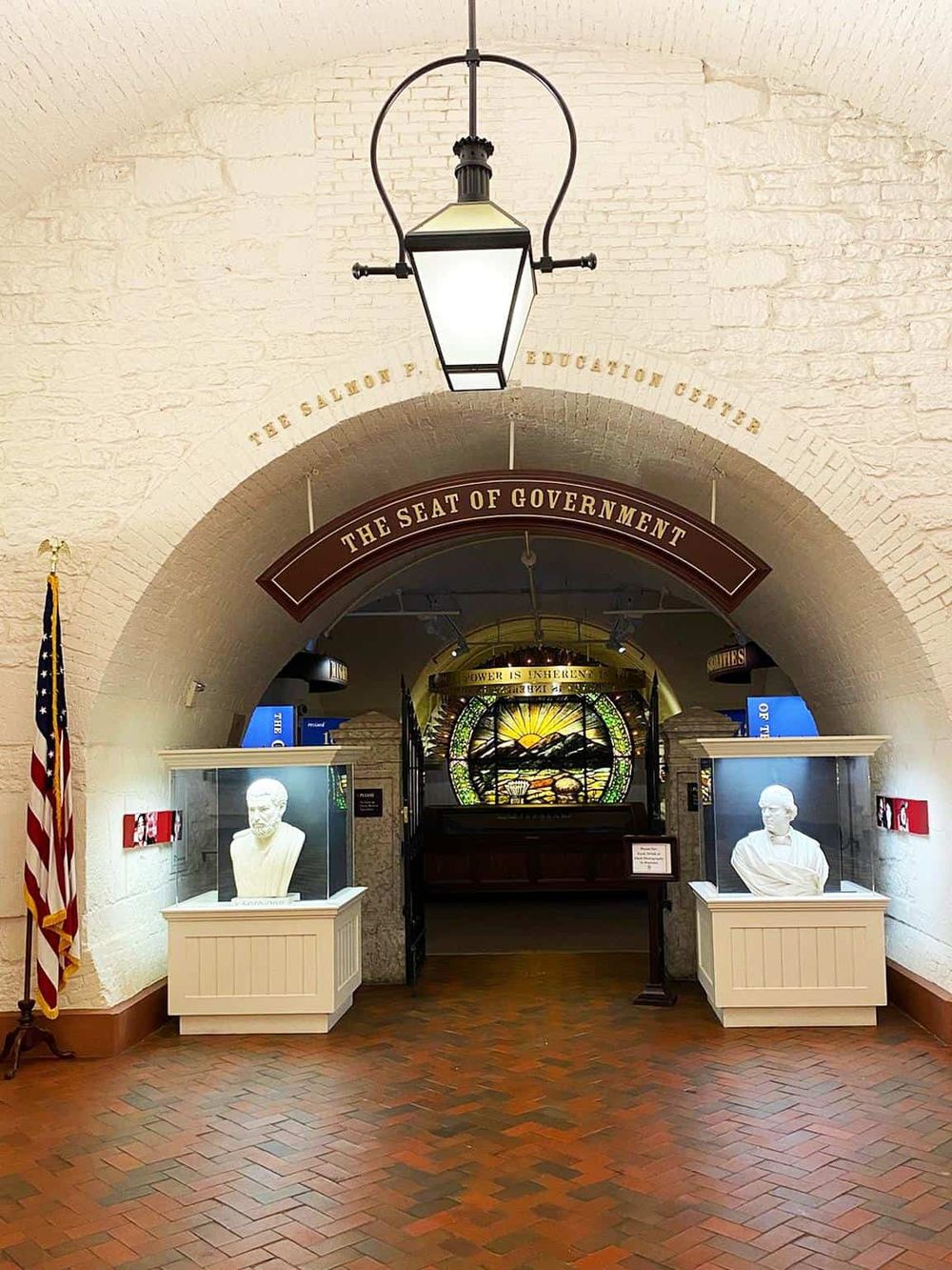 Historic government building interior with busts and stained glass, emphasizing political and educational significance.
