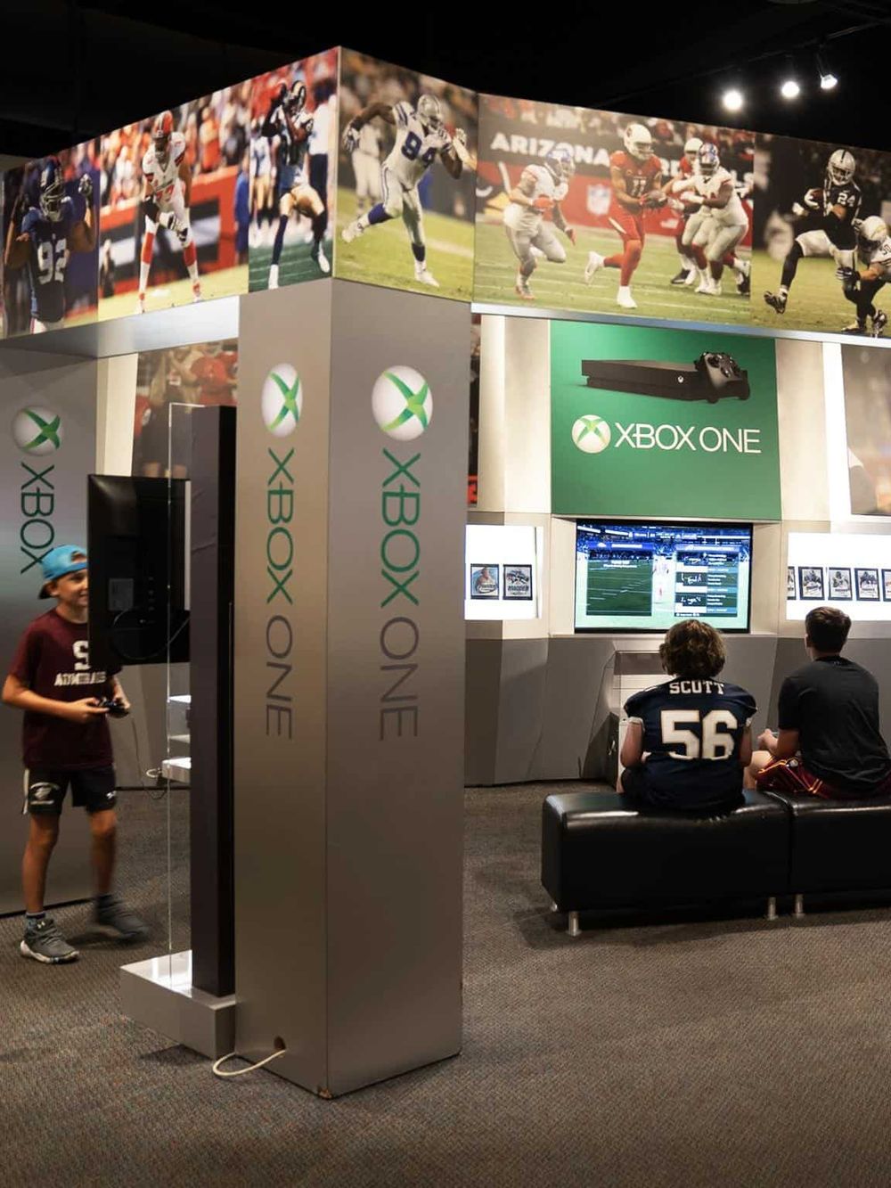 Sports video game arcade with Xbox One and football fans playing.