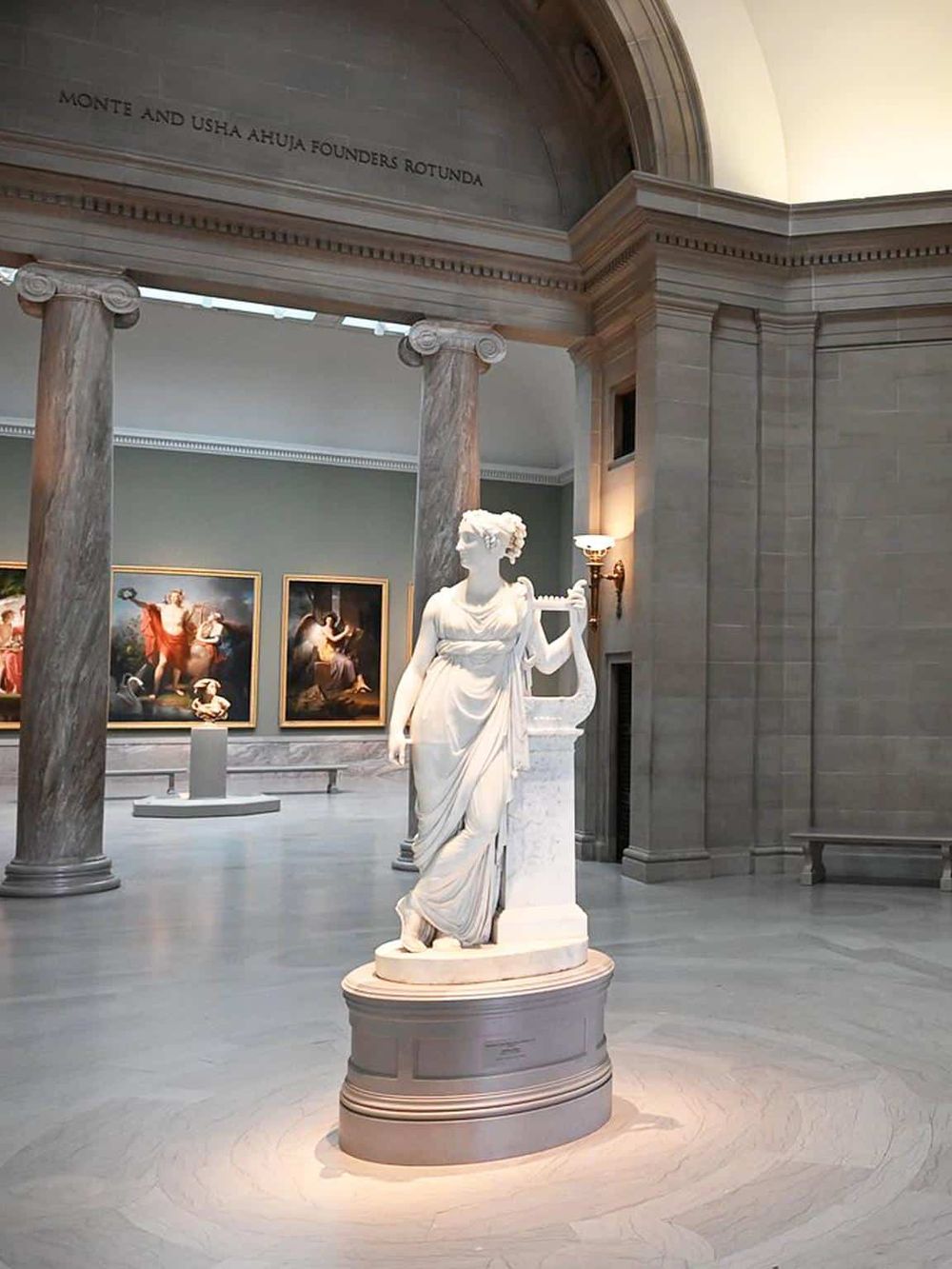 Marble Greek goddess sculpture at QuestForDirections museum, classical art display, grand interior architecture.