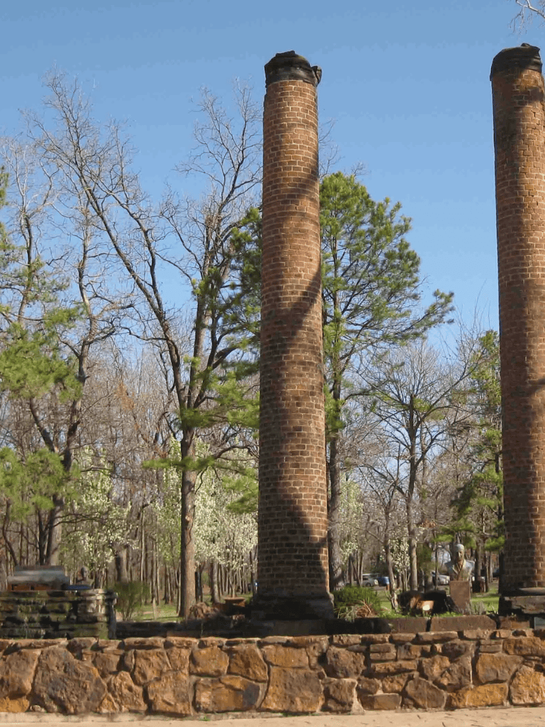 Weathered brick chimneys in historic site, nature backdrop, walking paths near Quest for Directions.