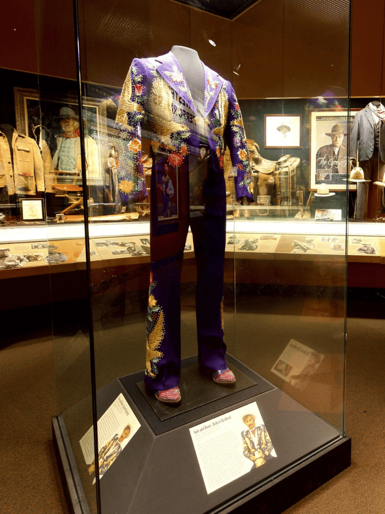 Colorful embroidered jumpsuit on display in museum exhibit, highlighting historical fashion and celebrity style.