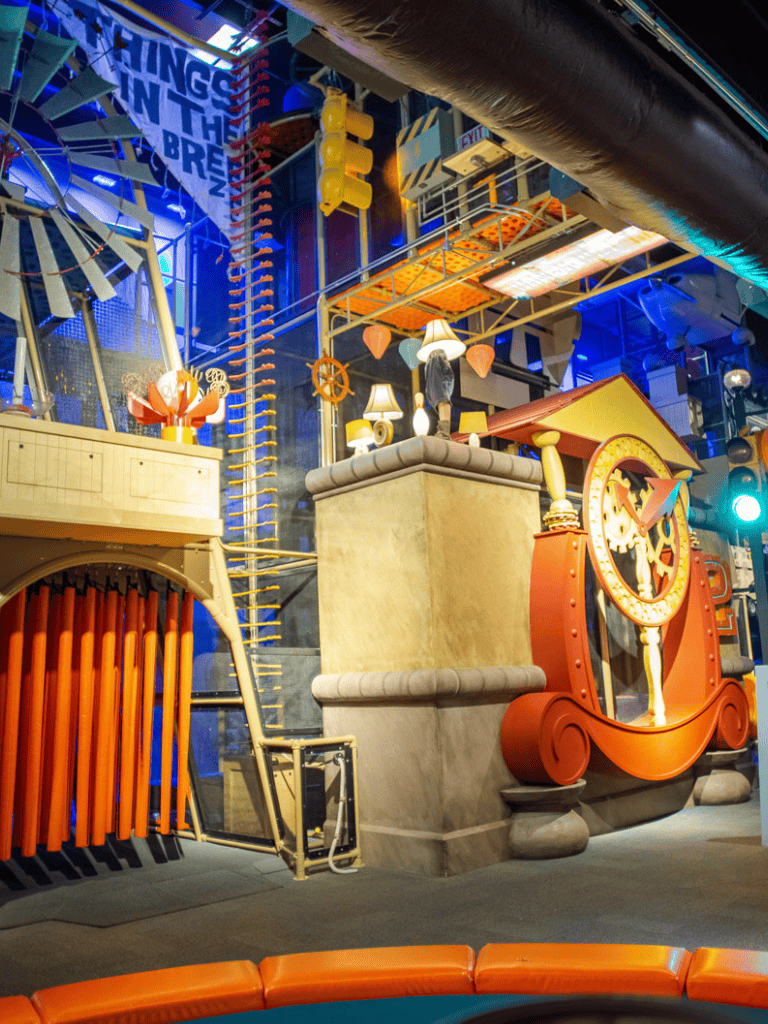 Colorful indoor play area with interactive clocks and climbing structures at Quest for Directions.