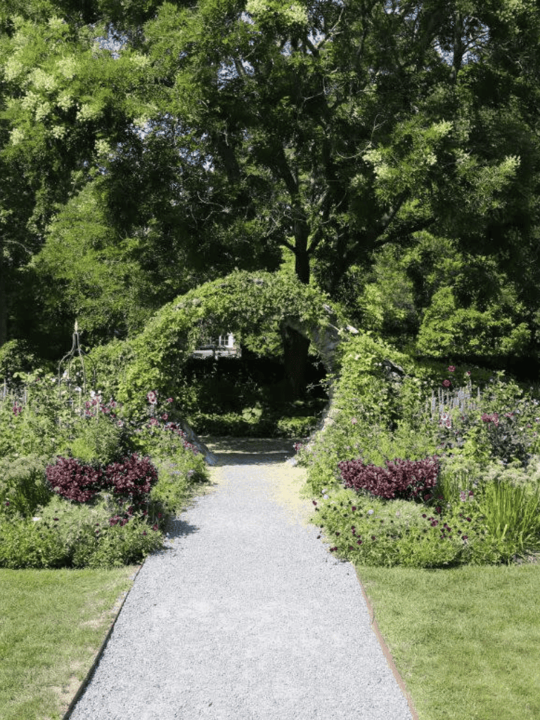 Lush garden path with archway and vibrant flowers, ideal for peaceful outdoor exploration.