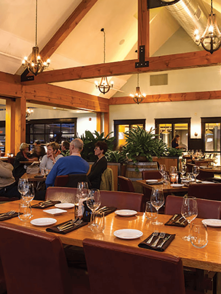 High-end restaurant interior with wooden beams, elegant lighting, and dining setup for special occasions.